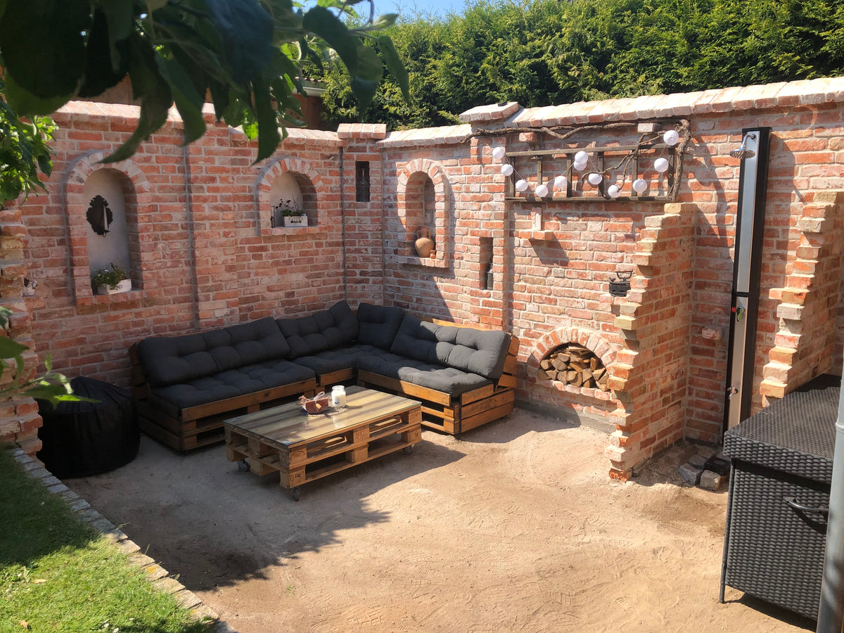 Terrasse mit Ruinenmauer aus alten Ziegelsteinen