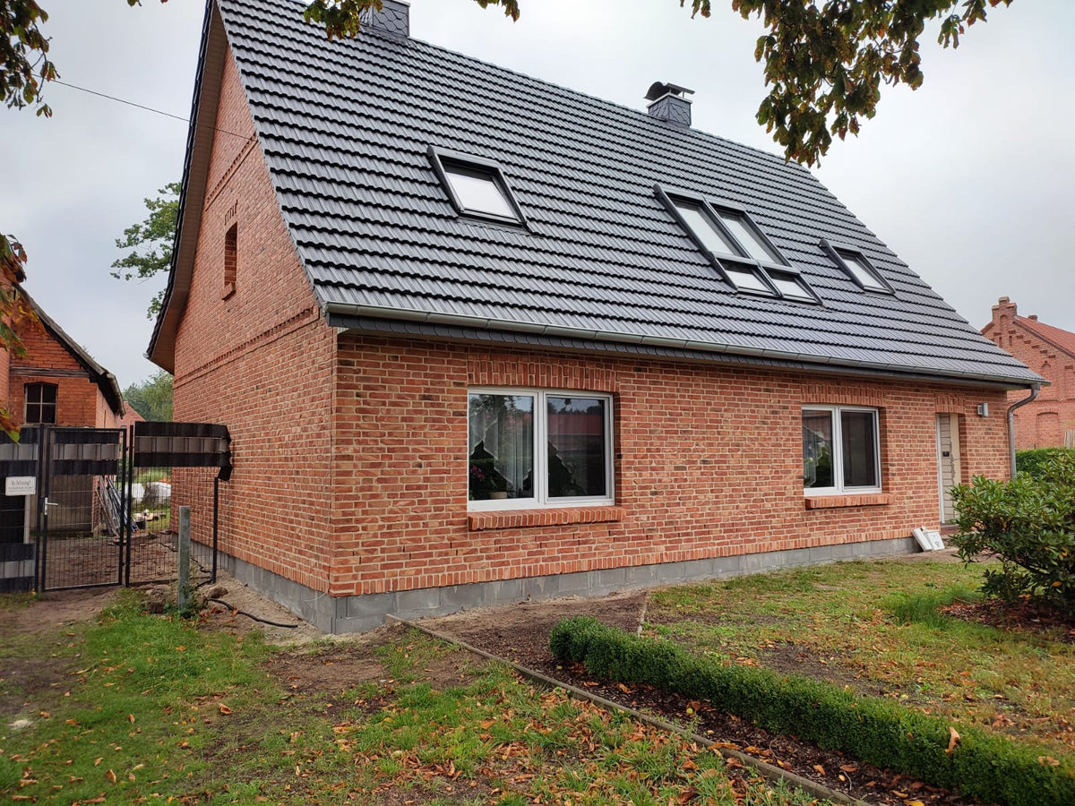 Einfamilienhaus mit Fassade aus roten Ziegelsteinen und Satteldach