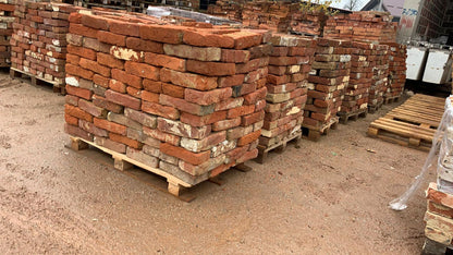 Paletten mit alten dunkelroten Ziegelsteinen